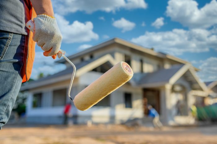 Professional painter working on the outside of a new construction home